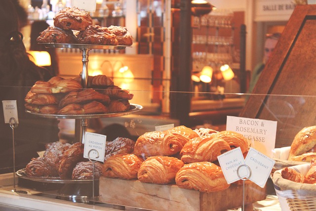 Cosy interior of a premium artisan food and coffee shop with warm wooden shelving units displaying bags of speciality coffee glass jars of colourful loose leaf tea and rows of spice containers illuminated by pendant lighting