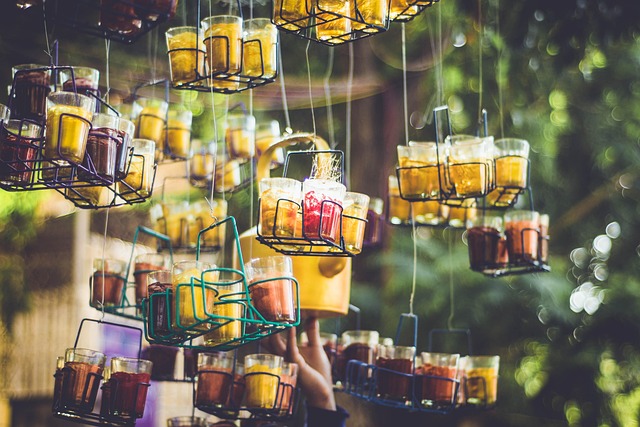 Rich amber Assam black tea liquor being poured from a glass teapot into a clear glass cup with whole malty black tea leaves scattered on a wooden tray