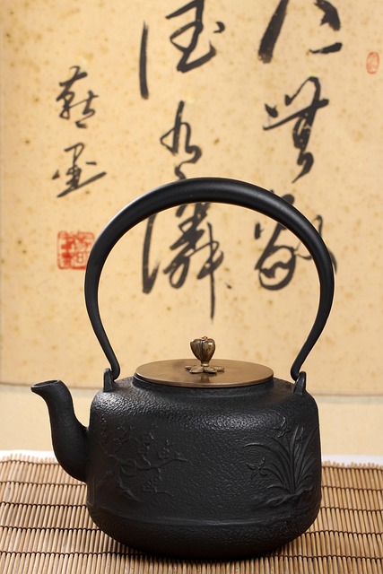 Dark oolong tea leaves partially unfurled in a warm clay teapot with rich amber tea liquor in small traditional tasting cups on an aged wooden tea table